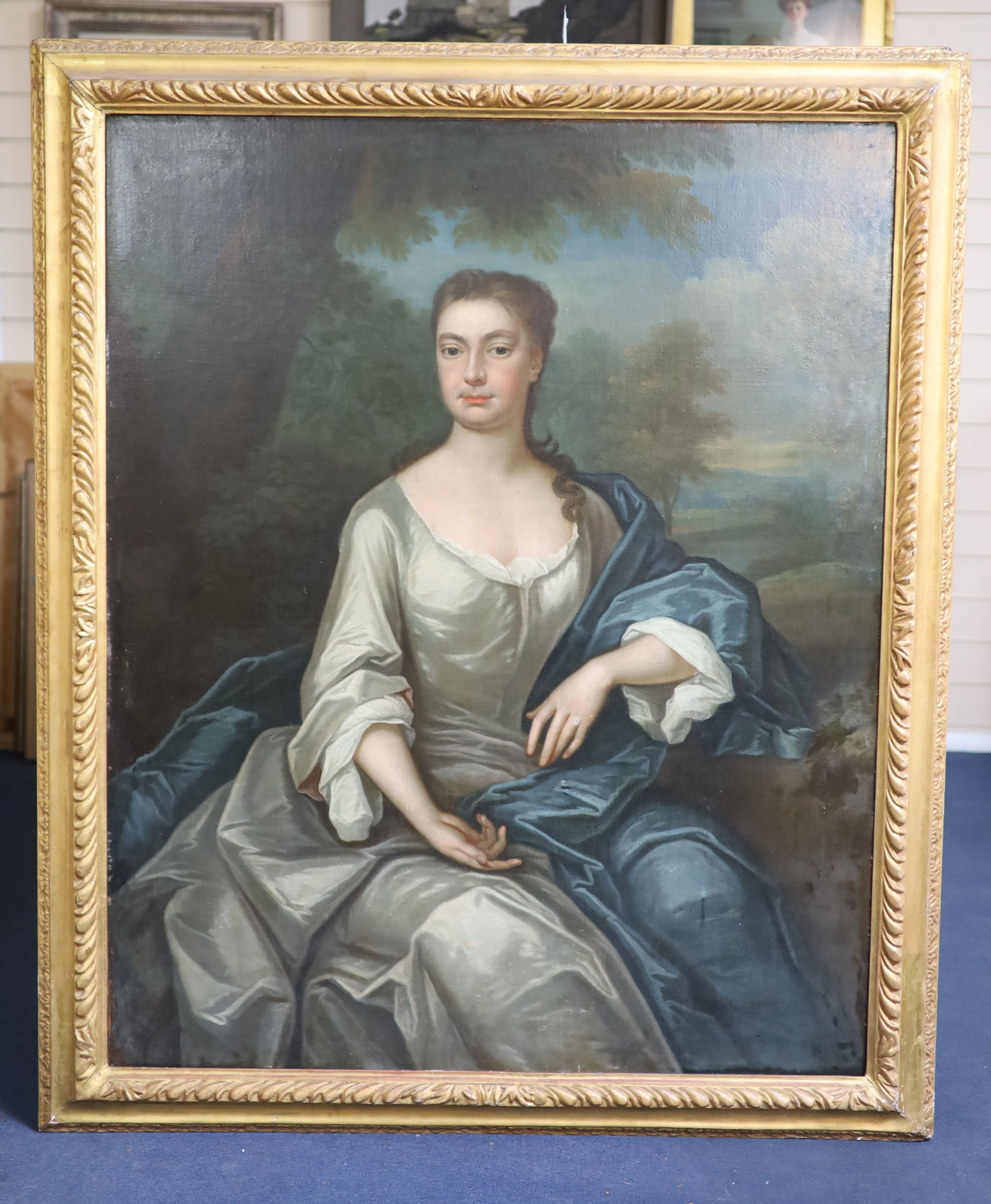 Circle of Sir Godfrey Kneller (1646-1723), Three quarter length portrait of a lady seated in a landscape, oil on canvas, 125 x 100cm